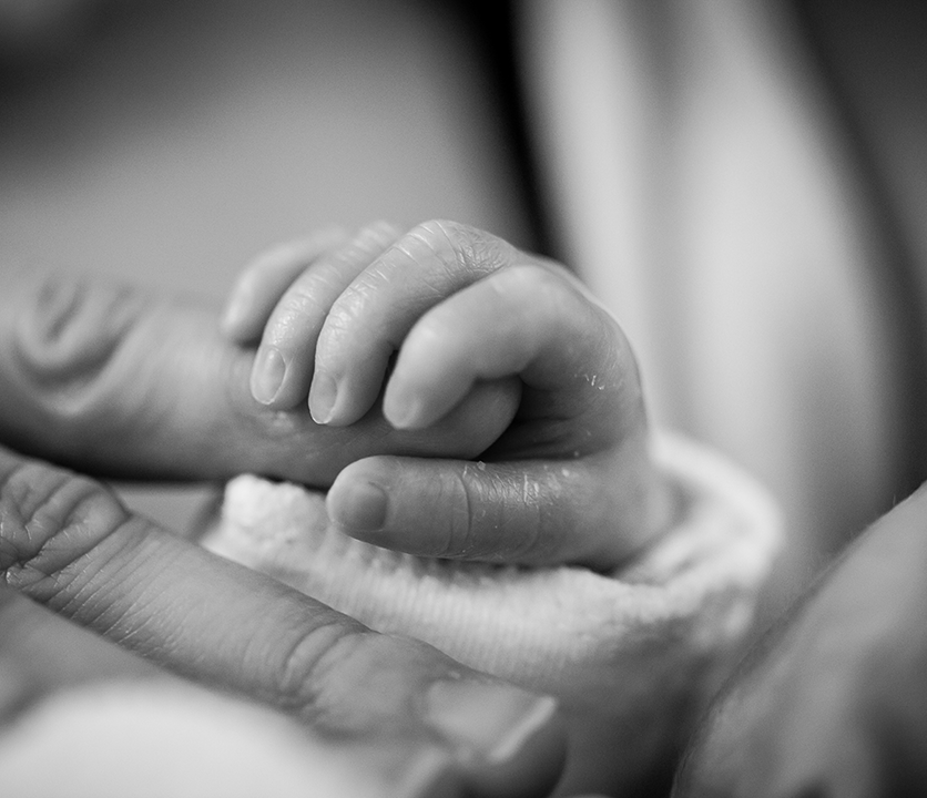 baby hand holding an adult finger